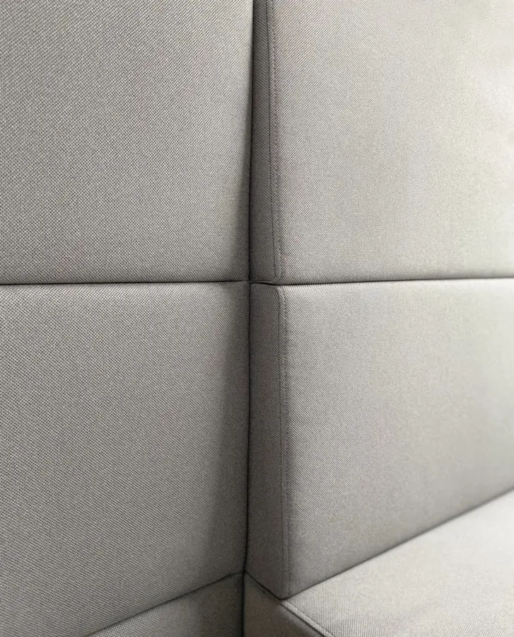 Soft sound-absorbing panels inside the L booth — upholstered walls absorb sound