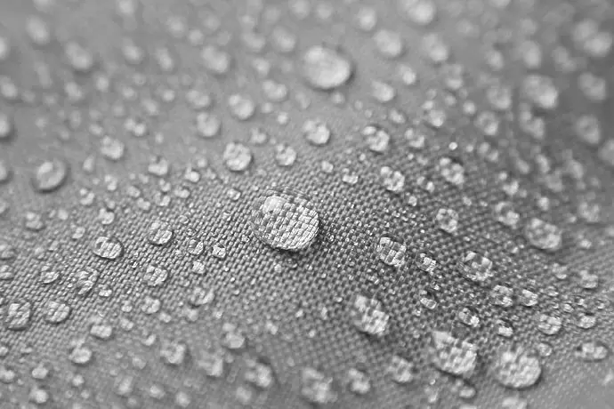 Hydrophobic upholstery fabric in L booth — water droplets repelled, easy to clean